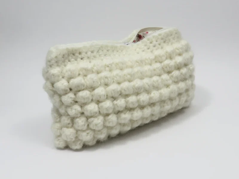 Beauty case crochet bianco, con fodera in cotone con motivo floreale.