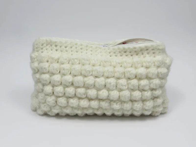 Beauty case crochet bianco, con fodera in cotone con motivo floreale.