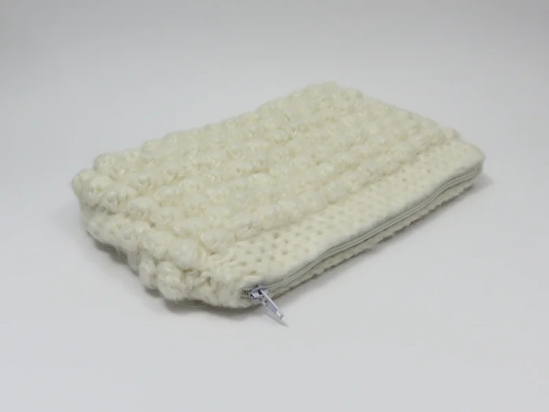 Beauty case crochet bianco, con fodera in cotone con motivo floreale.