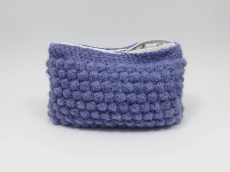 Beauty case crochet viola, foderato con tessuto di cotone con motivo floreale.