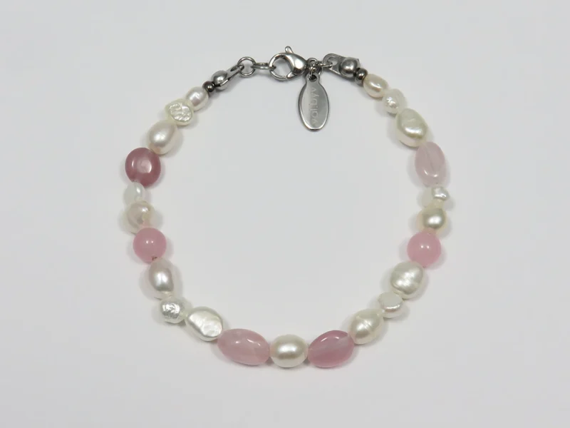 Bracciale in quarzo rosa, con perle di fiume bianche e chiusura a moschettone.