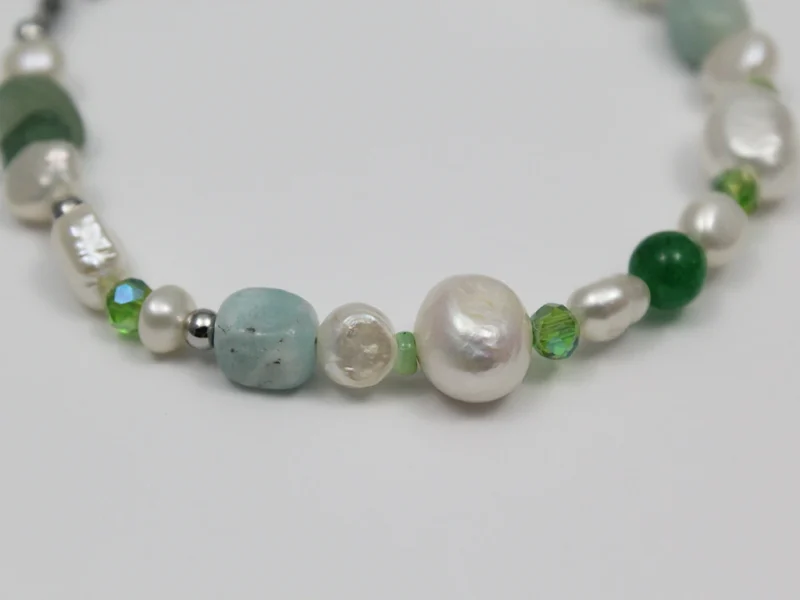 Bracciale di perle e pietre verdi, con chiusura a moschettone.