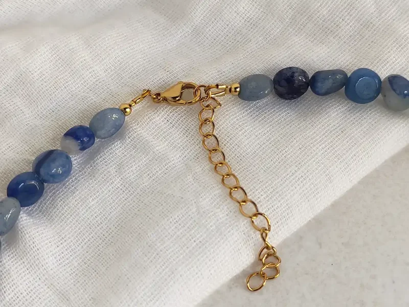 Collana con avventurina blu, chiusura a moschettone e catenella di estensione dorata.