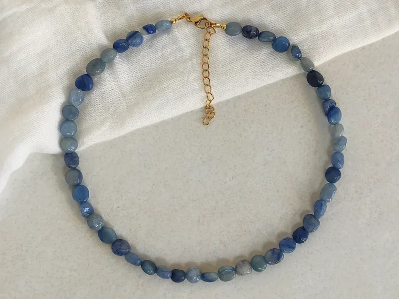 Collana con avventurina blu, chiusura a moschettone e catenella di estensione dorata.