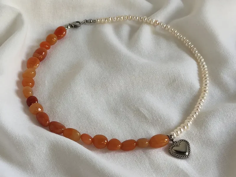 Collana con avventurina rossa, perle di fiume bianche e ciondolo centrale a forma di cuore.