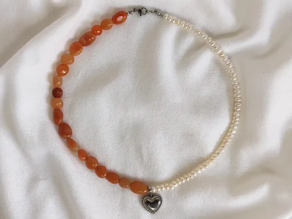 Collana con avventurina rossa, perle di fiume bianche e ciondolo centrale a forma di cuore.