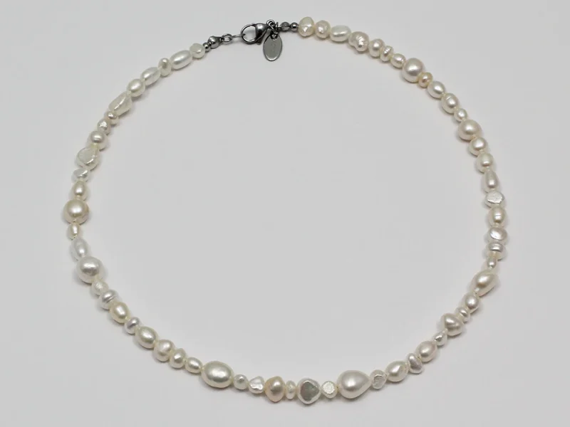 Collana di perle di fiume miste, di varie forme e dimensioni irregolari, con chiusura a moschettone.