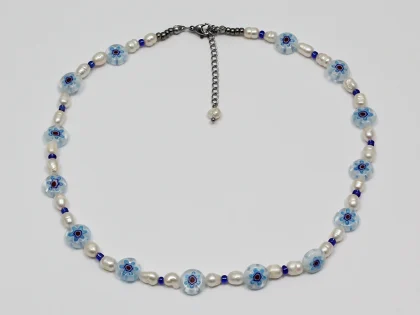 Collana in vetro murano blu, con perle di fiume irregolari e perline in vetro, con chiusura a moschettone e catenella di estensione.