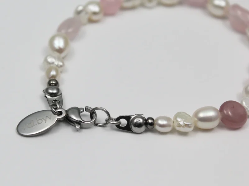 Bracciale in quarzo rosa, con perle di fiume bianche e chiusura a moschettone.