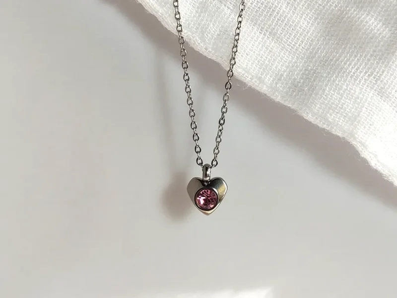 Collana con ciondolo a forma di cuore, con brillante rosa e catenella in acciaio inox.