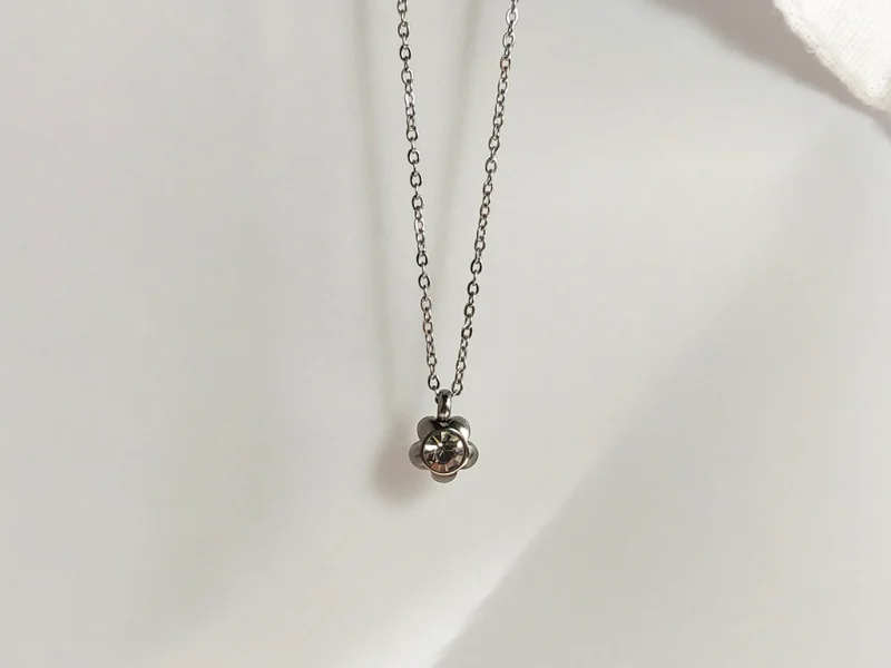 Collana con ciondolo a forma di fiore, con brillante bianco centrale, in acciaio inossidabile.