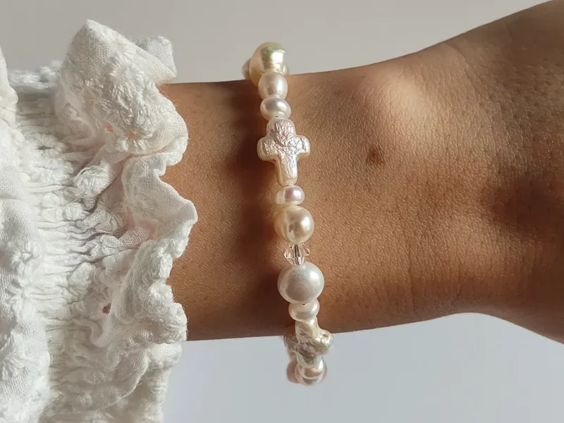 Bracciale di perle con croci, indossato.