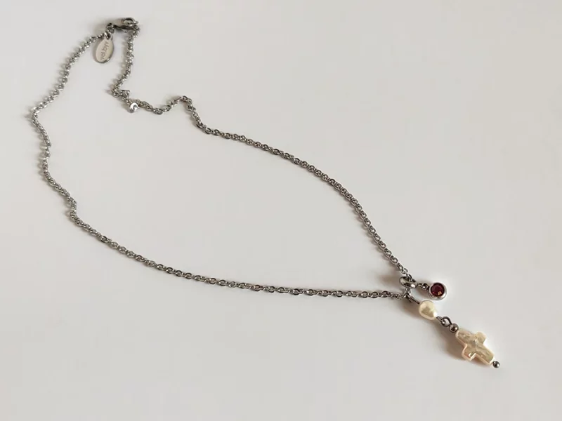 Collana con ciondoli. Pendenti in acciaio inox con brillante rosso e perla di fiume a forma di croce.