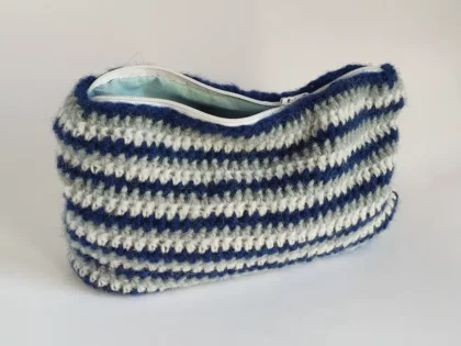 Beauty case crochet a righe blu, in lana di baby alpaca, foderata in cotone e con cerniera a zip.