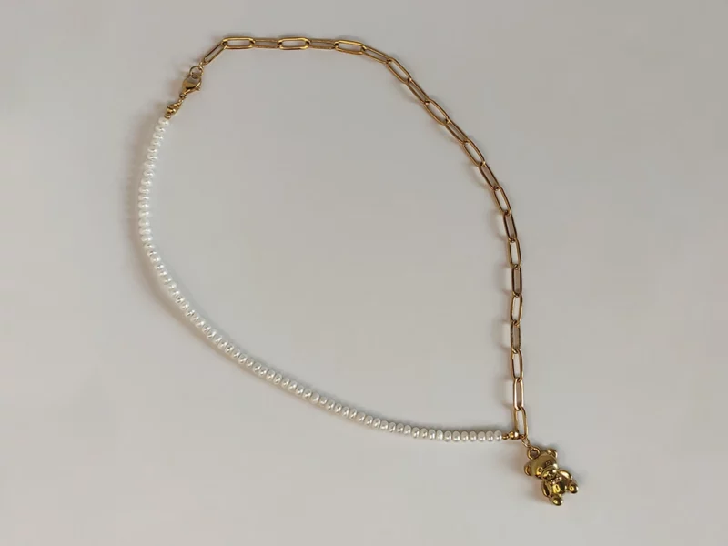 Collana con orsetto, metà in perle di fiume e metà catenella in acciaio inox dorato.