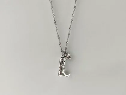 Collana "cowgirl", con ciondolo a forma di stivale da Cowboy argentato e fiore con brillante bianco centrale, con catenella in acciaio inox.